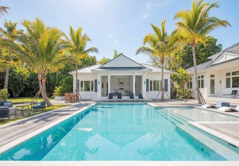 Luxury pool with sun deck at Naples Florida home with palm trees and clear blue water maintained by professional pool service
